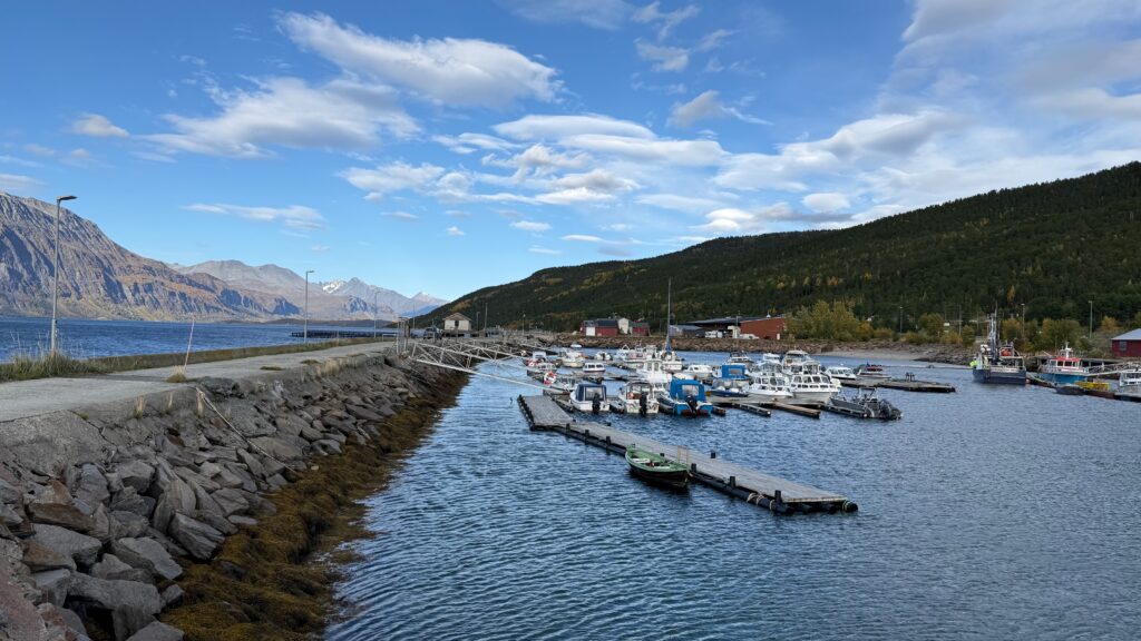 Pienvenesatama vuonon rannalla vuorten ympäröimänä.