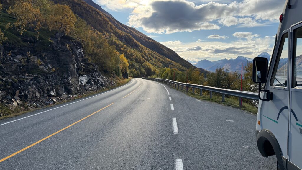 Asuntoauto näkyy vuorten välisellä maantiellä.