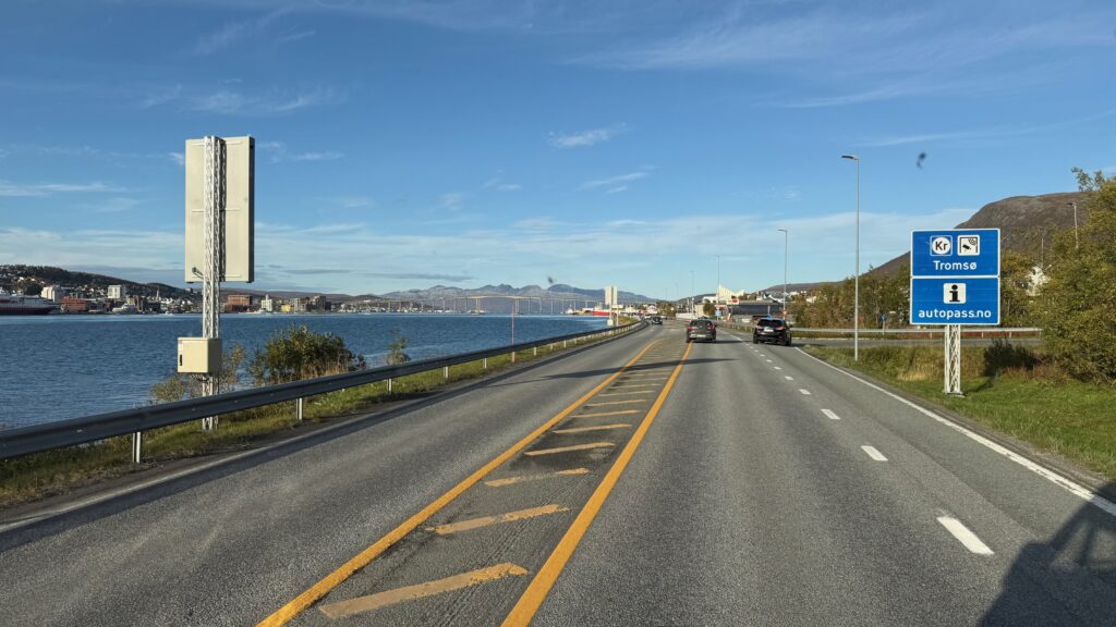 Tie johtaa sillalle vuonon ja vuorten maisemassa.